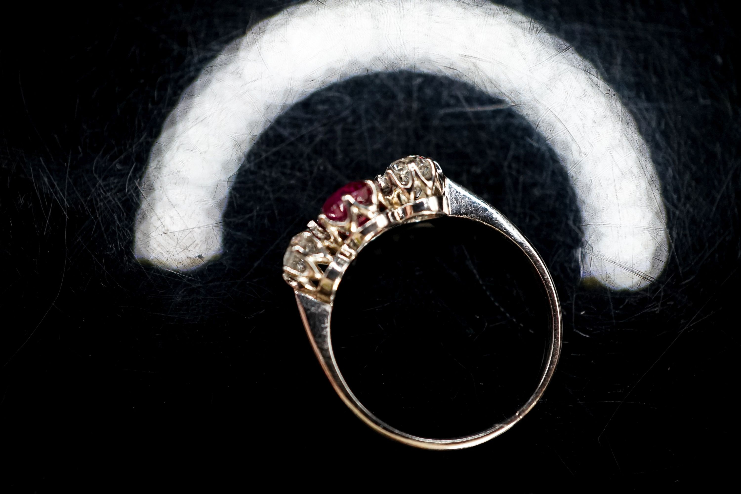 A white metal single stone ruby and two stone diamond ring, size L/M, gross weight 3 grams.